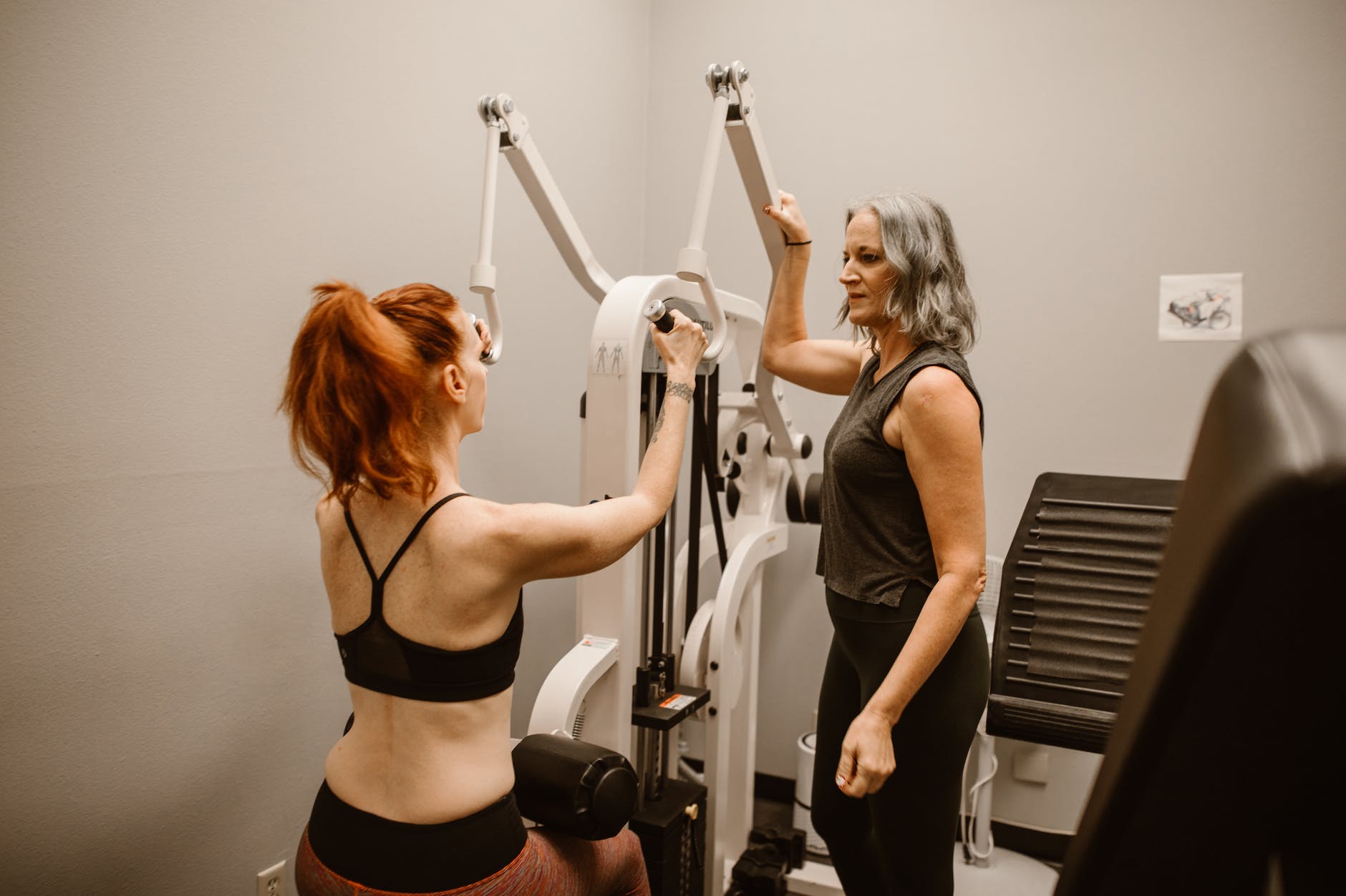 two women standing beside a gym equipment