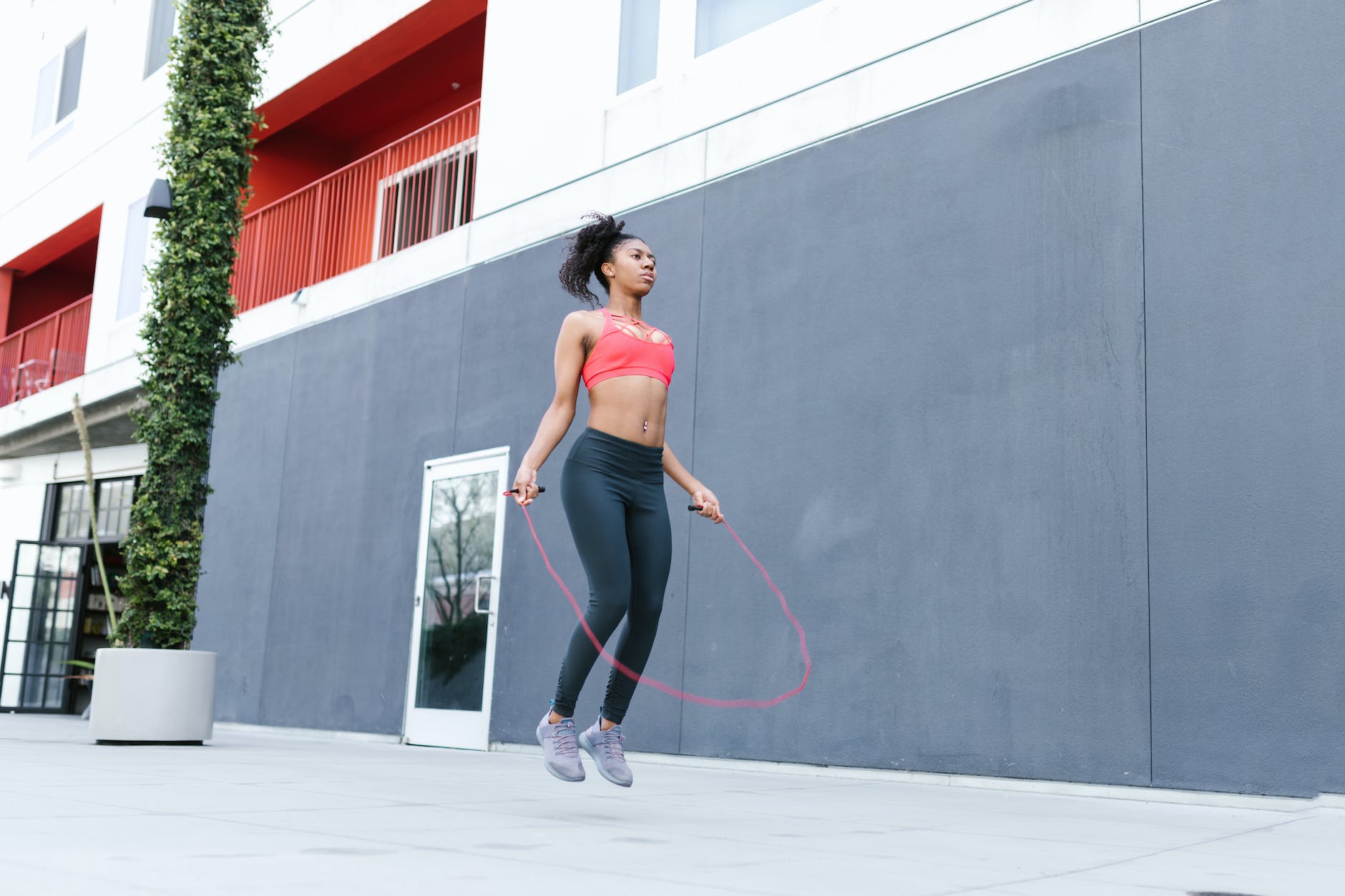 woman wearing a sports bra and leggings skipping rope